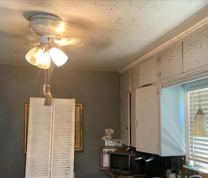 Soot on white cabinets and ceiling, ceiling fan and light are on